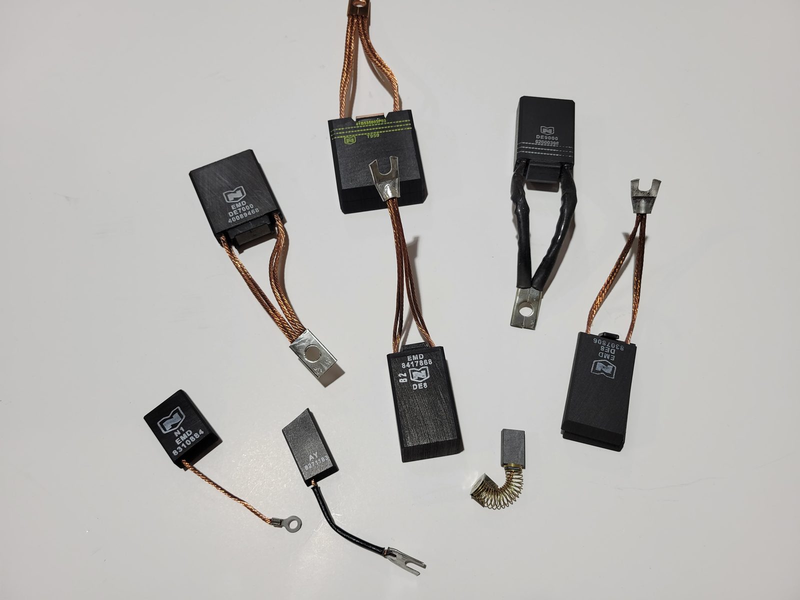 EMD locomotive carbon brushes with copper shunts and terminal lugs, including DE8, DE7000 and DE9000 grades